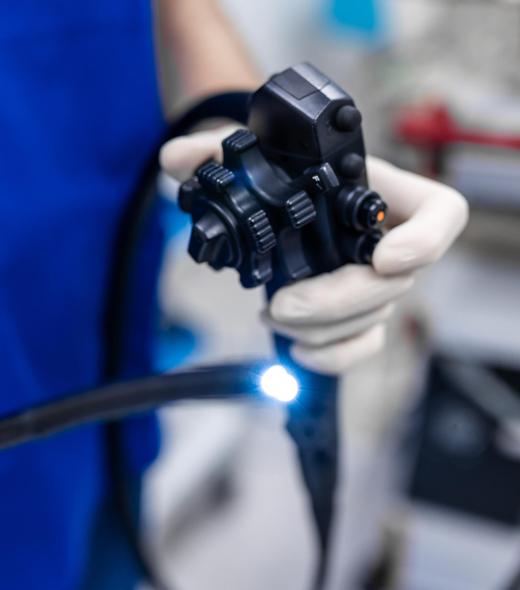 Doctor proctologist holding endoscope during colonoscopy. Probe colonoscope. Doctor gastroenterologist with probe to perform gastroscopy and colonoscopy Doctor proctologist holding endoscope during colonoscopy. Probe colonoscope. Doctor gastroenterologist with probe to perform gastroscopy and colonoscopy
